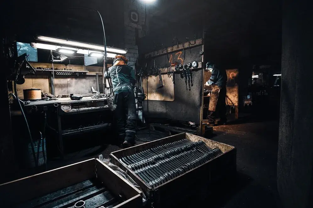 dark workshop experienced worker protective uniform is working with metal 613910 17236